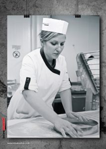 Photographie en noir et blanc d'une pâtissière au travail