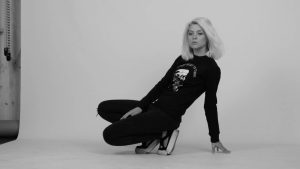 Une femme modèle photo est en train de poser sur un fond blanc