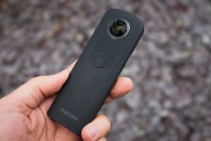 Un homme tient la caméra Ricoh Theta S dans sa main
