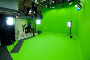 Plusieurs spots de lumières sont posés dans un studio fond vert